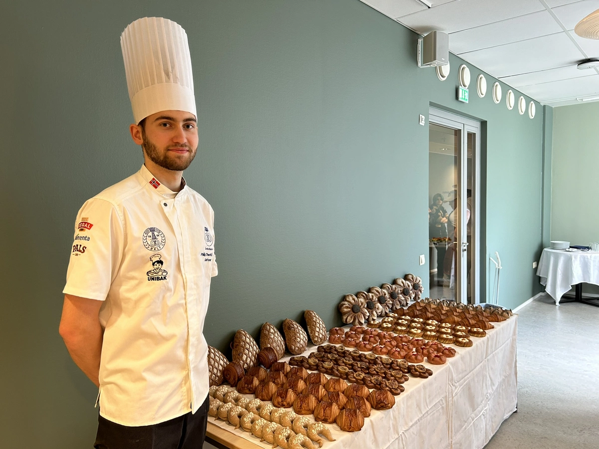 Philip Therkildsen står ved et bord med sine bakeriprodukter i konkurransen NM Årets Baker 2024.